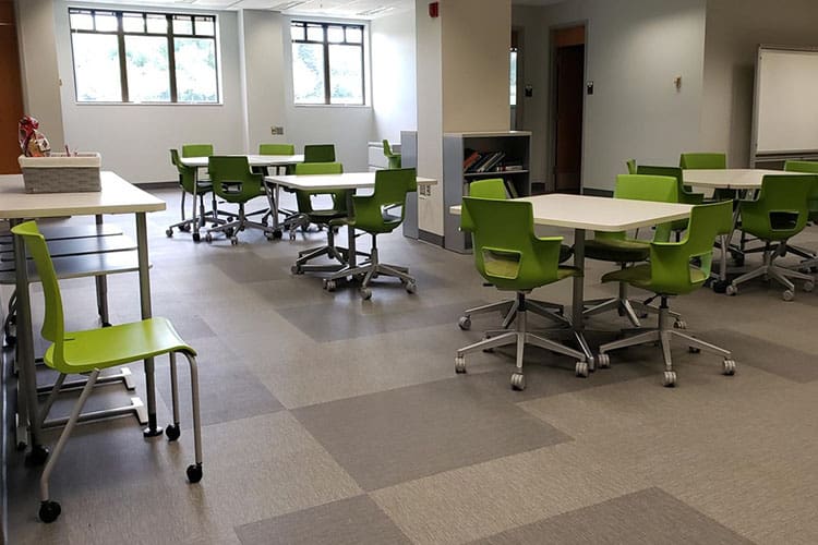 Green chairs around a classroom