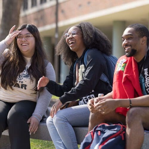 PNW students sit outdoors on campus