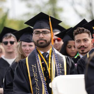 Students sit in commencement regalia during the Spring 2024 commencement ceremony